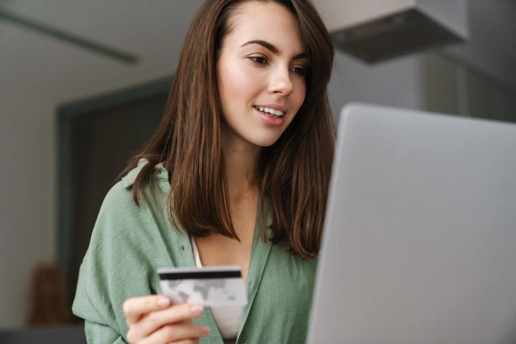 A girl by the laptop with credit card in hand