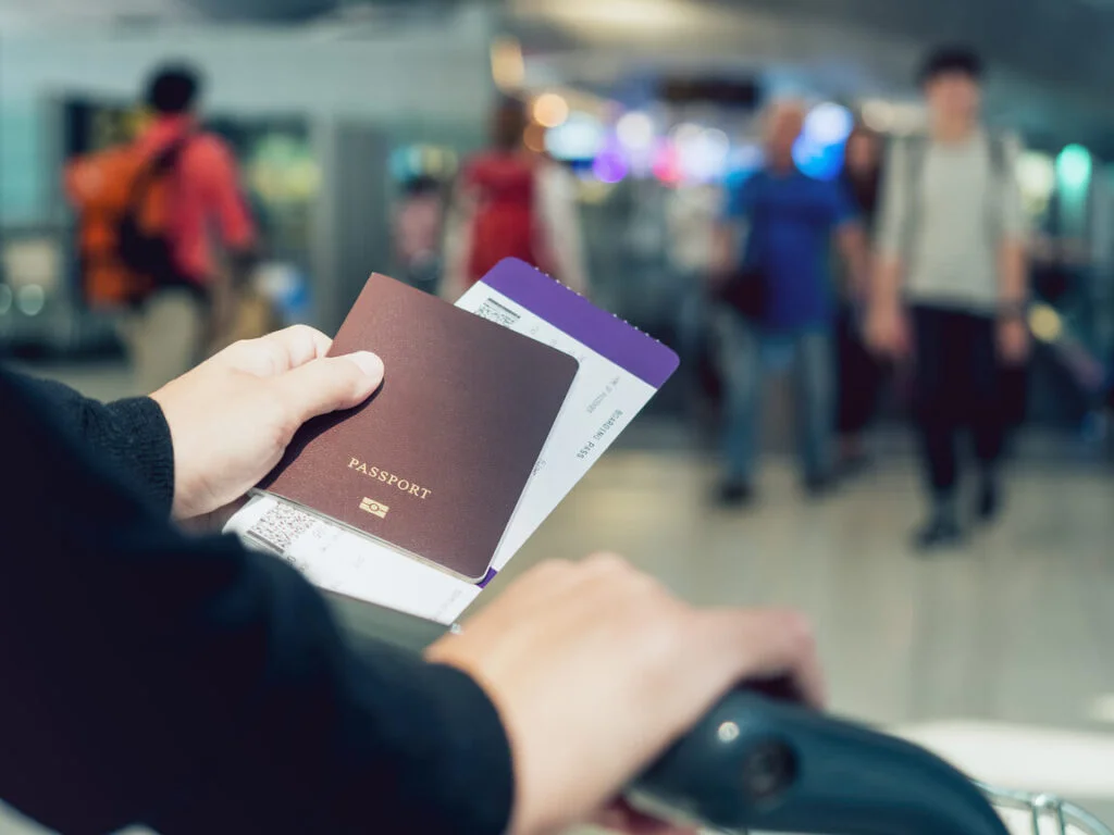 Person waiting in transport station with a passport in hand