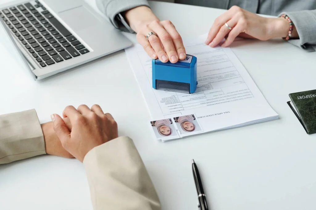 Two persons by the table filling paperwork