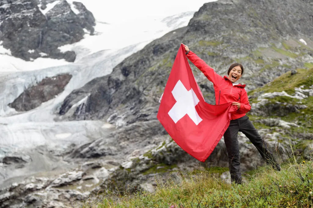 A woman holding Swiss flag in her hands