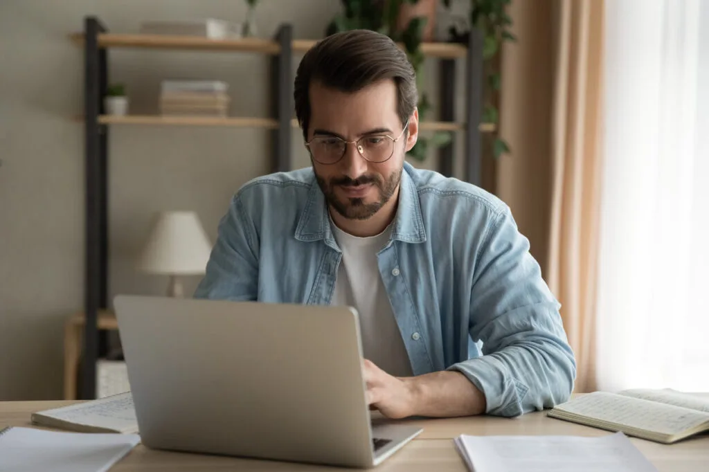 A man siting by the laptop